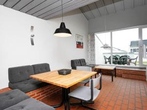 salon z drewnianym stołem i krzesłami w obiekcie Apartment Brovst II w mieście Brovst