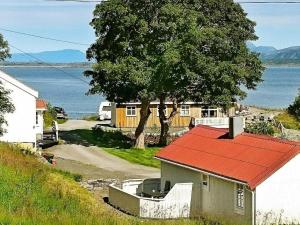 una casa con techo rojo junto a un árbol en 4 person holiday home in VEVANG-By Traum, en Vevang