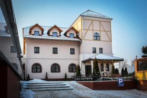 ein großes weißes Gebäude mit einem Turm darüber in der Unterkunft Hotel Madelaine in Lwówek Śląski