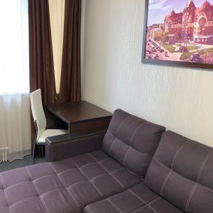 a living room with a couch and a desk at Hotel Prestige in Barnaul