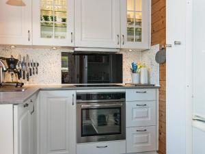 a kitchen with white cabinets and an oven at 6 person holiday home in Glesborg in Fjellerup