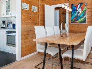 a dining room with a wooden table and white chairs at 6 person holiday home in Glesborg in Fjellerup