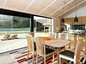 uma cozinha e sala de jantar com uma mesa de madeira e cadeiras em 8 person holiday home in Hj rring em Hjørring