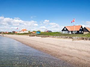 ヒュールスミンネにある5 person holiday home in Juelsmindeの家屋旗が掲げられた浜