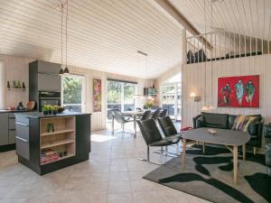 a kitchen and living room with a table and chairs at 7 person holiday home in Bl vand in Blåvand