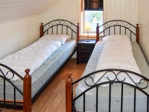 two twin beds in a room with a window at 10 person holiday home in Folkestad in Folkestad