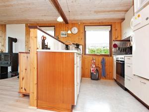 uma cozinha com paredes de madeira e um forno de fogão branco em 5 person holiday home in Juelsminde em Sønderby