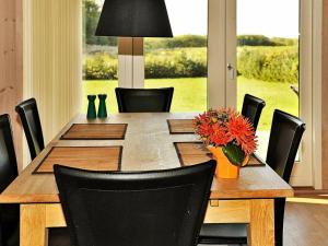 stół jadalny z krzesłami i wazon z kwiatami w obiekcie 6 person holiday home in Ansager w mieście Ansager