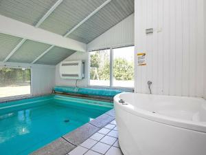 La salle de bains est pourvue d'une baignoire et d'une piscine. dans l'établissement 10 person holiday home in Hj rring, à Lønstrup