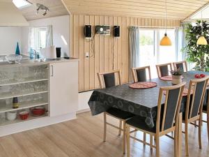 a kitchen and dining room with a table and chairs at 8 person holiday home in V ggerl se in Marielyst