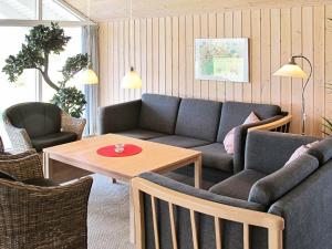 a living room with a couch and a table and chairs at 8 person holiday home in V ggerl se in Marielyst