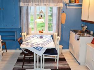 una pequeña cocina con mesa y ventana en Three-Bedroom Holiday home in Gullesfjord en Flesnes