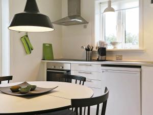 a kitchen with a table and chairs and a kitchen with a counter at 5 person holiday home in Harbo re in Harboør