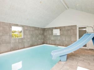 basen z niebieską zjeżdżalnią w pokoju w obiekcie Two-Bedroom Holiday home in Tomrefjord w mieście Gørlev