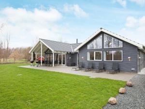 a gray house with a lawn in front of it at 18 person holiday home in H jby in Højby