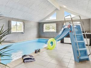 a indoor swimming pool with a slide and an inflatable at 20 person holiday home in V ggerl se in Marielyst