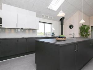 a kitchen with black cabinets and a black counter top at 20 person holiday home in V ggerl se in Marielyst