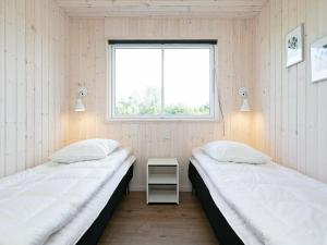 two beds in a room with a window at 20 person holiday home in V ggerl se in Marielyst