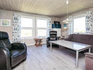 スナーヴィグにある6 person holiday home in Ringk bingのリビングルーム(革製家具、テーブル付)