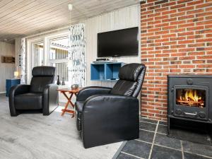 sala de estar con 2 sillas y chimenea en 6 person holiday home in Ringk bing, en Søndervig