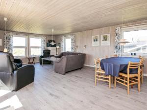 sala de estar con mesa, sillas y sofá en 6 person holiday home in Ringk bing, en Søndervig