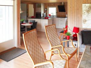 a living room with two chairs and a kitchen at 6 person holiday home in L kken in Grønhøj