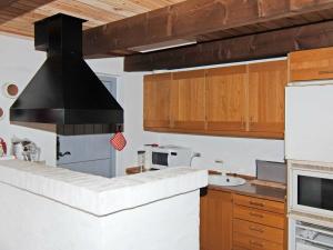 ブラーバンドにある5 person holiday home in Bl vandの木製のキャビネットと黒いフード付きのキッチン