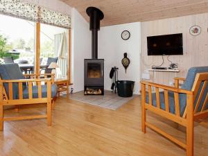 a living room with a fireplace and a tv at 6 person holiday home in Hemmet in Falen