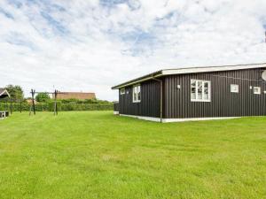 a black house with a large grass yard at 8 person holiday home in Hemmet in Hemmet