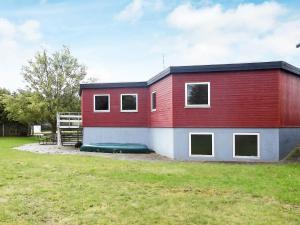 a red and white building with a grass field at 30 person holiday home in Nordborg in Nordborg