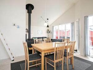 a dining room with a wooden table and chairs at 6 person holiday home in Hvide Sande in Hvide Sande