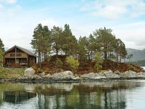 une maison sur une petite île dans l'eau dans l'établissement Two-Bedroom Holiday home in Vågland 6, à Bårdset