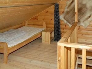 a room with a bed in a log cabin at 5 person holiday home in VÅGLAND in Bårdset