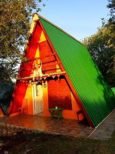 Casa pequeña con techo verde y patio en Cabañas Pancho Segunda Usina en Embalse