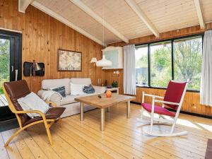 Ålbækにある4 person holiday home in lb kのリビングルーム(ソファ、テーブル、椅子付)