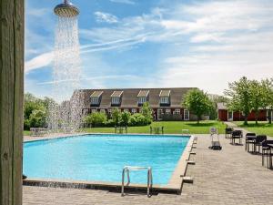 a swimming pool with a fountain in front of a building at Apartment Aakirkeby in Åkirkeby