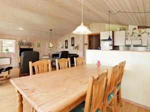 a dining room and kitchen with a wooden table and chairs at 6 person holiday home in Hemmet in Hemmet