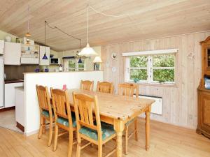 een keuken en eetkamer met een houten tafel en stoelen bij 6 person holiday home in Hemmet in Hemmet