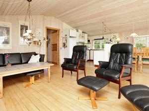 een woonkamer met zwarte lederen stoelen en een tafel bij 6 person holiday home in Hemmet in Hemmet