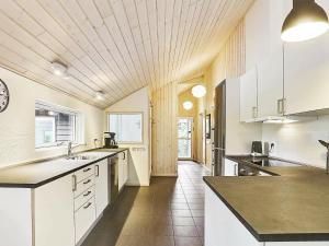 a large kitchen with white cabinets and black counter tops at Luxury Beach Retreat - By Traum Ferienwohnungen in Tisvildeleje