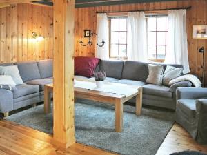 ein Wohnzimmer mit einem Sofa und einem Couchtisch in der Unterkunft 11 person holiday home in Edland in Vågsli