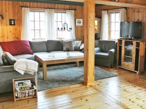een woonkamer met een bank en een tafel bij 11 person holiday home in Edland in Vågsli