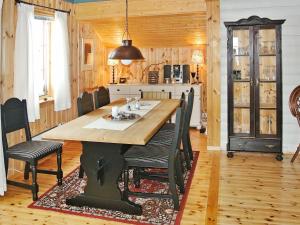 a kitchen and dining room with a table and chairs at 11 person holiday home in Edland in Vågsli