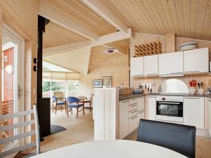 une cuisine avec des placards blancs et une salle à manger dans l'établissement Holiday home Asnæs III, à Asnæs