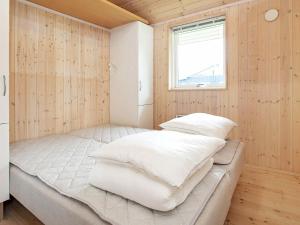 Ce lit se trouve dans un dortoir doté de murs en bois et d'une fenêtre. dans l'établissement Holiday home Asnæs III, à Asnæs