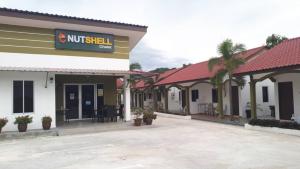 a motel with a not shell sign in a parking lot at The Nutshell Chalet Langkawi in Pantai Cenang