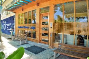 a wooden building with a bench in front of it at Equatorial Divers Lodge in Feydhoo