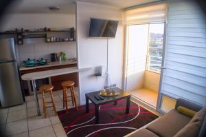ein Wohnzimmer mit Couch und Tisch und eine Küche in der Unterkunft Hermoso departamento a pasos de playa Peñuelas La Serena in Coquimbo + 11 Fotos