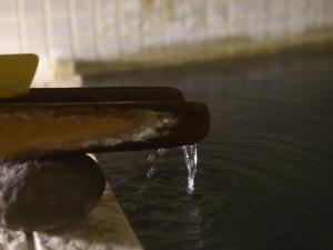 a close up of water pouring out of a water tap at Tokiwaya in Nozawa Onsen