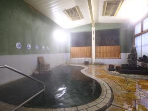 a large room with a pool of water in a building at Tokiwaya in Nozawa Onsen